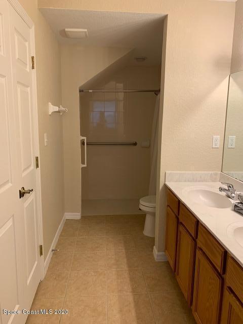110 Colibri Way, Unit 105 Melbourne, FL 32901 - Photo 8 of 16 a bathroom with a granite countertop sink a toilet and a shower