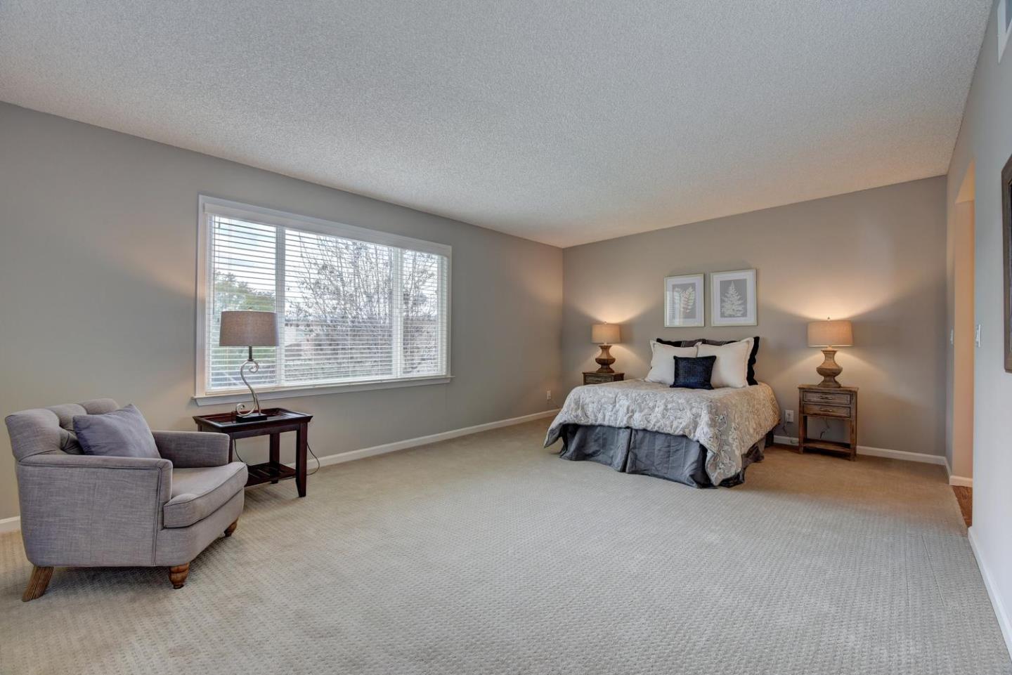 6429 McAbee Road San Jose, CA 95120 - Photo 15 of 28 a spacious bedroom with a bed and a couch