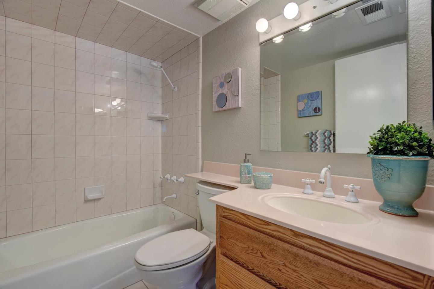 6429 McAbee Road San Jose, CA 95120 - Photo 23 of 28 a bathroom with a granite countertop sink a toilet a mirror and shower