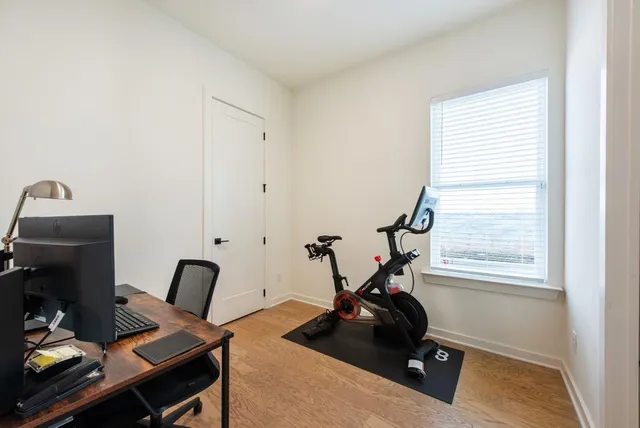 a view of a workspace with furniture and a gym cycle