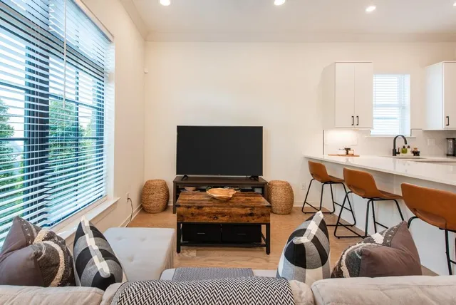 a living room with furniture a ceiling fan and a window