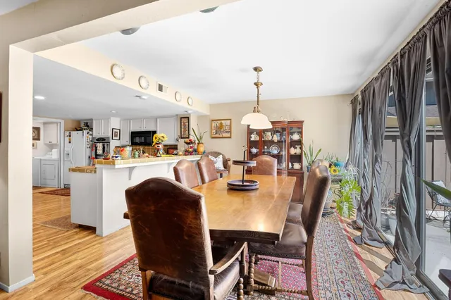 a dining room with furniture a chandelier and wooden floor