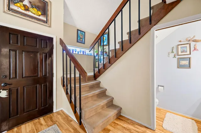 a view of staircase with lots of frames on wall and a window