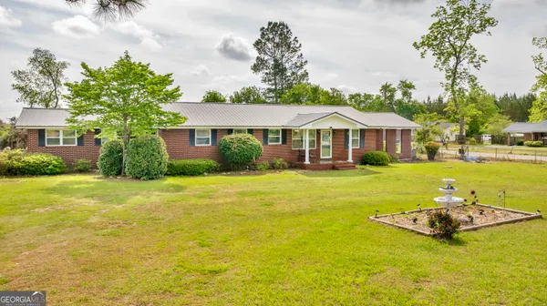 a front view of house with yard and swimming pool