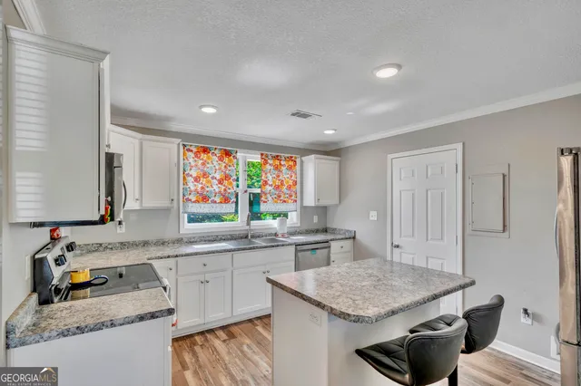 a kitchen with stainless steel appliances granite countertop a sink stove and cabinets