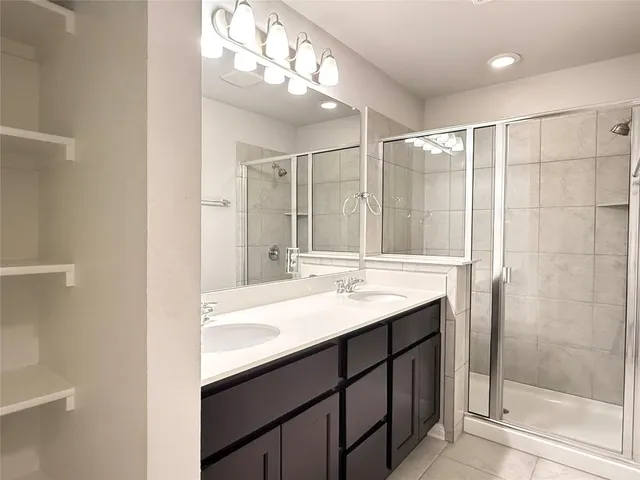 a bathroom with a double vanity sink mirror and shower