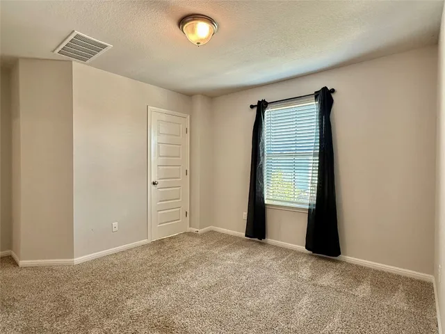 an empty room with closet and mirror