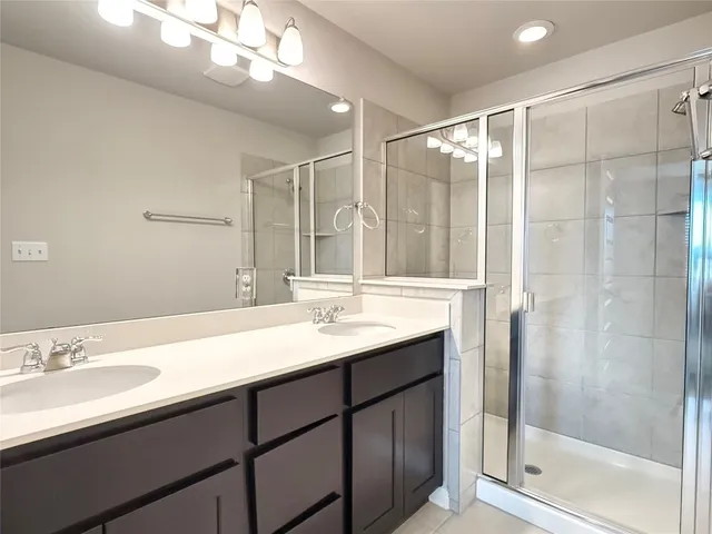 a bathroom with a shower sink and mirror