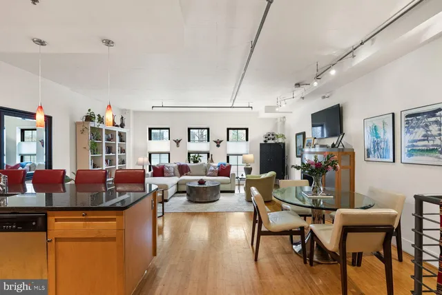a living room with furniture kitchen view and a large window