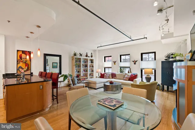 a living room with furniture a flat screen tv and kitchen view