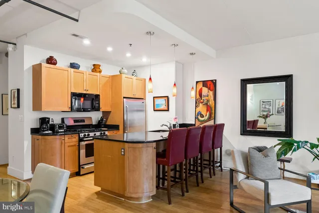 a living room with furniture kitchen view and a large window