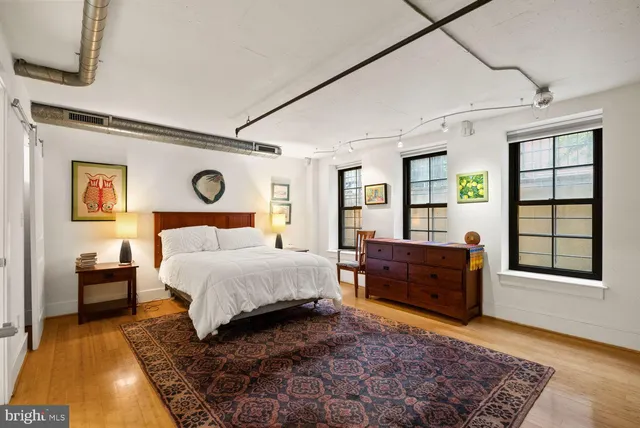 a bedroom with a bed and wooden floor