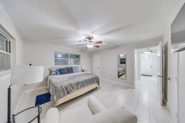 a spacious bedroom with a bed and a chandelier