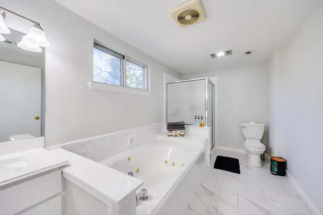 a bathroom with a tub sink and view of living room