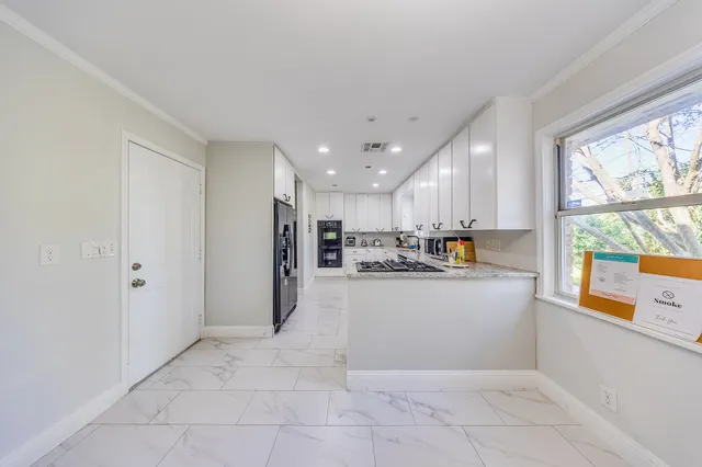 a view of kitchen with stainless steel appliances granite countertop a refrigerator and a sink