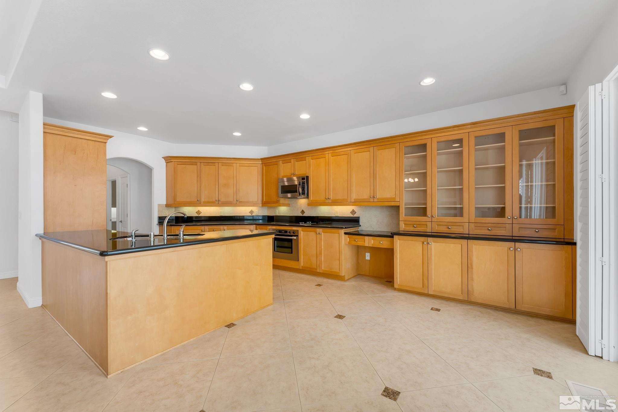 2681 Spearpoint Drive Reno, NV 89509 - Photo 12 of 36 a kitchen with stainless steel appliances granite countertop a stove and a refrigerator