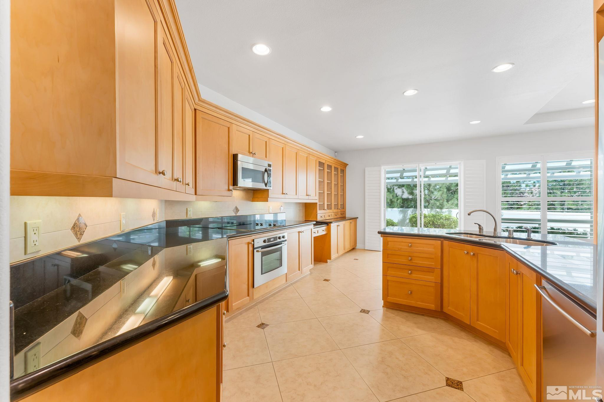2681 Spearpoint Drive Reno, NV 89509 - Photo 15 of 36 a large kitchen with stainless steel appliances granite countertop a sink and cabinets