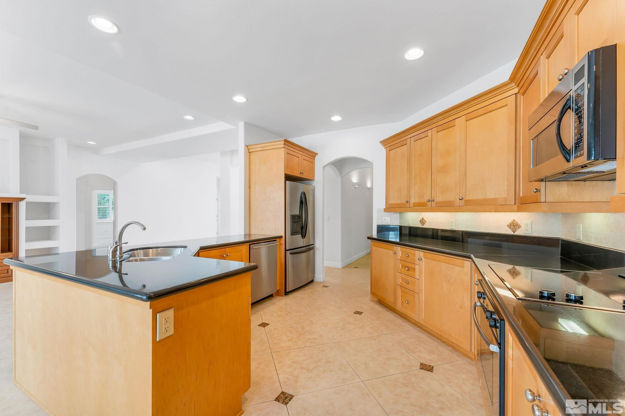 2681 Spearpoint Drive Reno, NV 89509 - Photo 16 of 36 a kitchen with stainless steel appliances granite countertop a sink a stove and a refrigerator