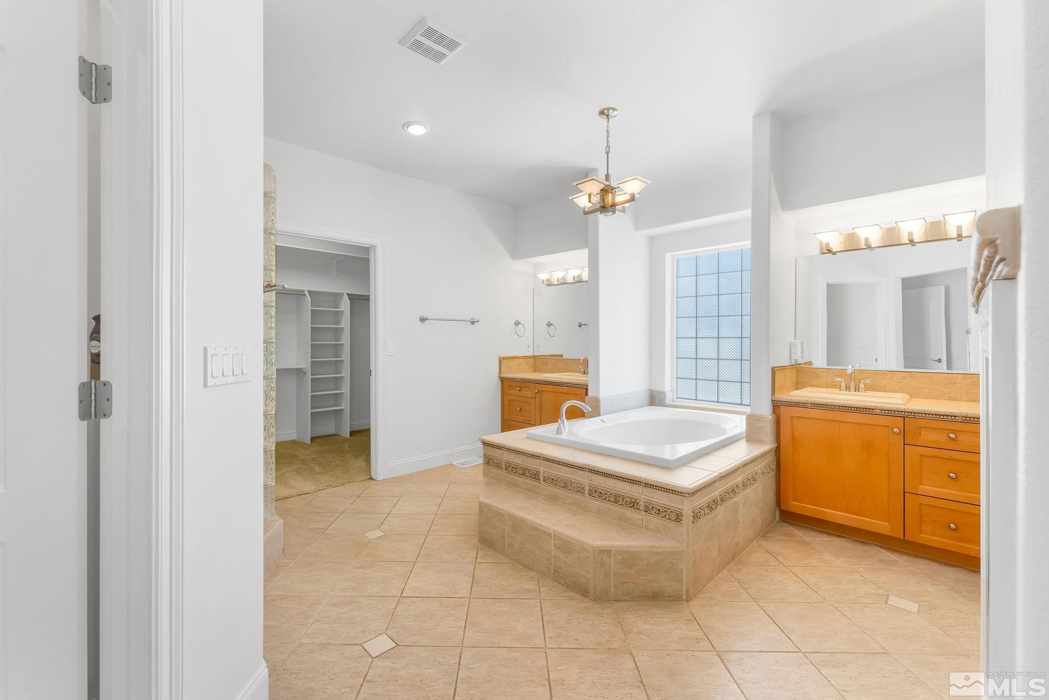 2681 Spearpoint Drive Reno, NV 89509 - Photo 19 of 36 a spacious bathroom with a granite countertop sink a mirror and a bathtub