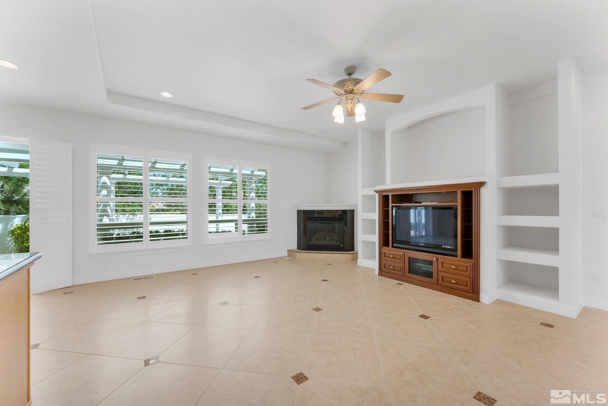 2681 Spearpoint Drive Reno, NV 89509 - Photo 9 of 36 a view of an empty room with a fireplace and a window