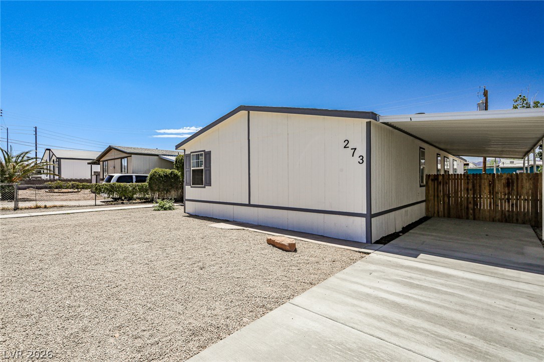 273 Aztec Lane Henderson, NV 89015 - Photo 2 of 28 A well-maintained manufactured home with convenient covered parking and a gravel yard.