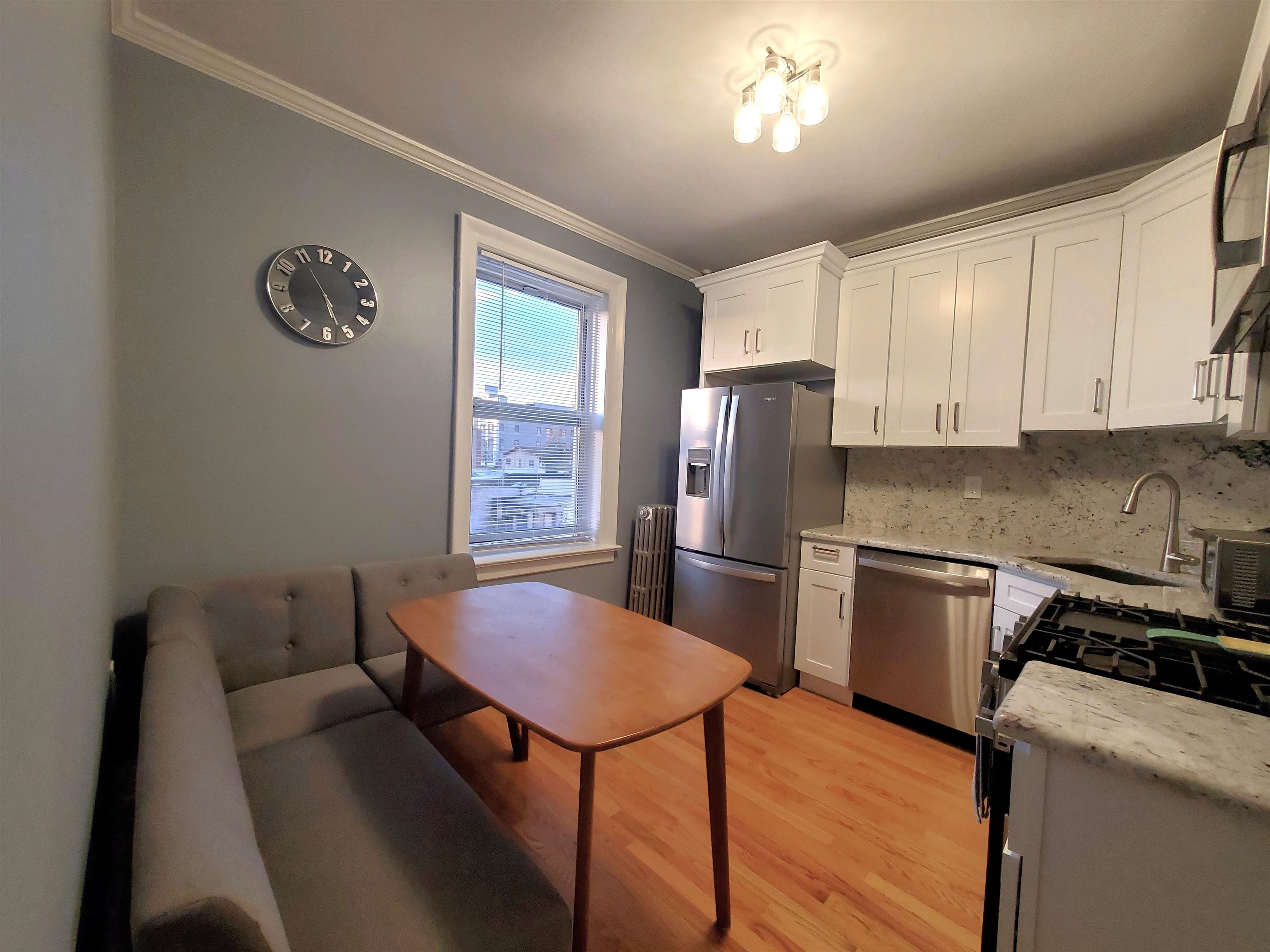 6701 Boulevard East, Unit E4 West New York, NJ 07093 - Photo 6 of 12 a kitchen with stainless steel appliances granite countertop a refrigerator a stove a sink dishwasher with a dining table and chairs