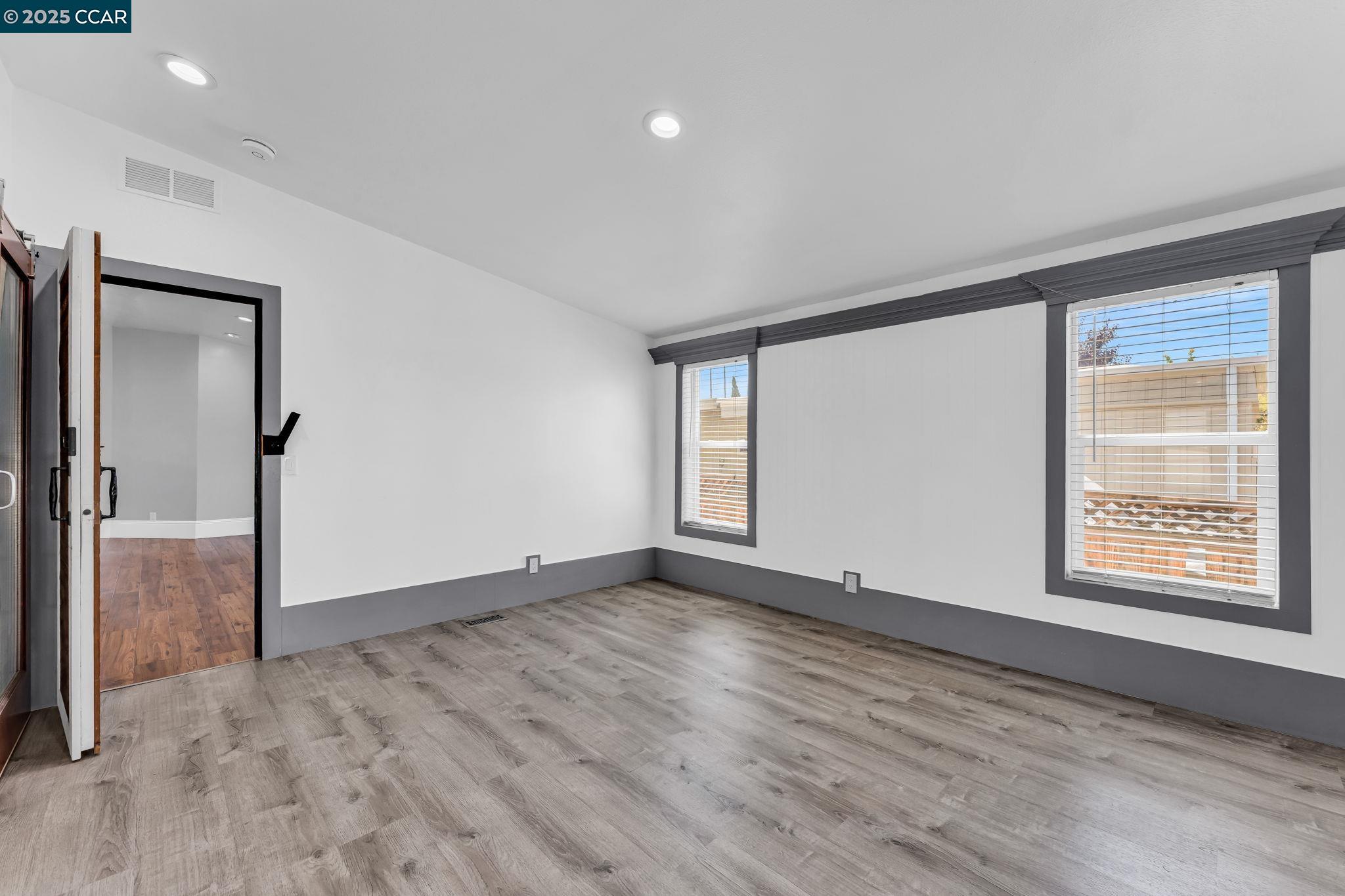 189 Suez Drive, Unit 72 Pacheco, CA 94553 - Photo 19 of 45 an empty room with wooden floor and windows