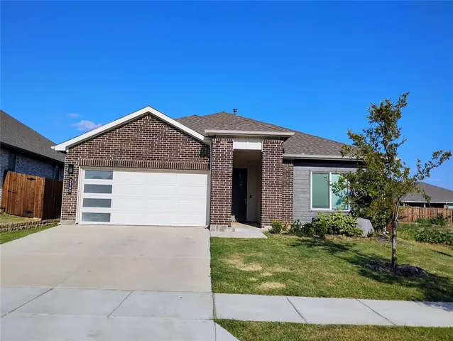 a front view of a house with a garden and yard