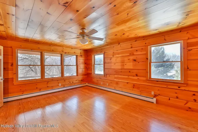 a view of a living room with a bed and wooden floor