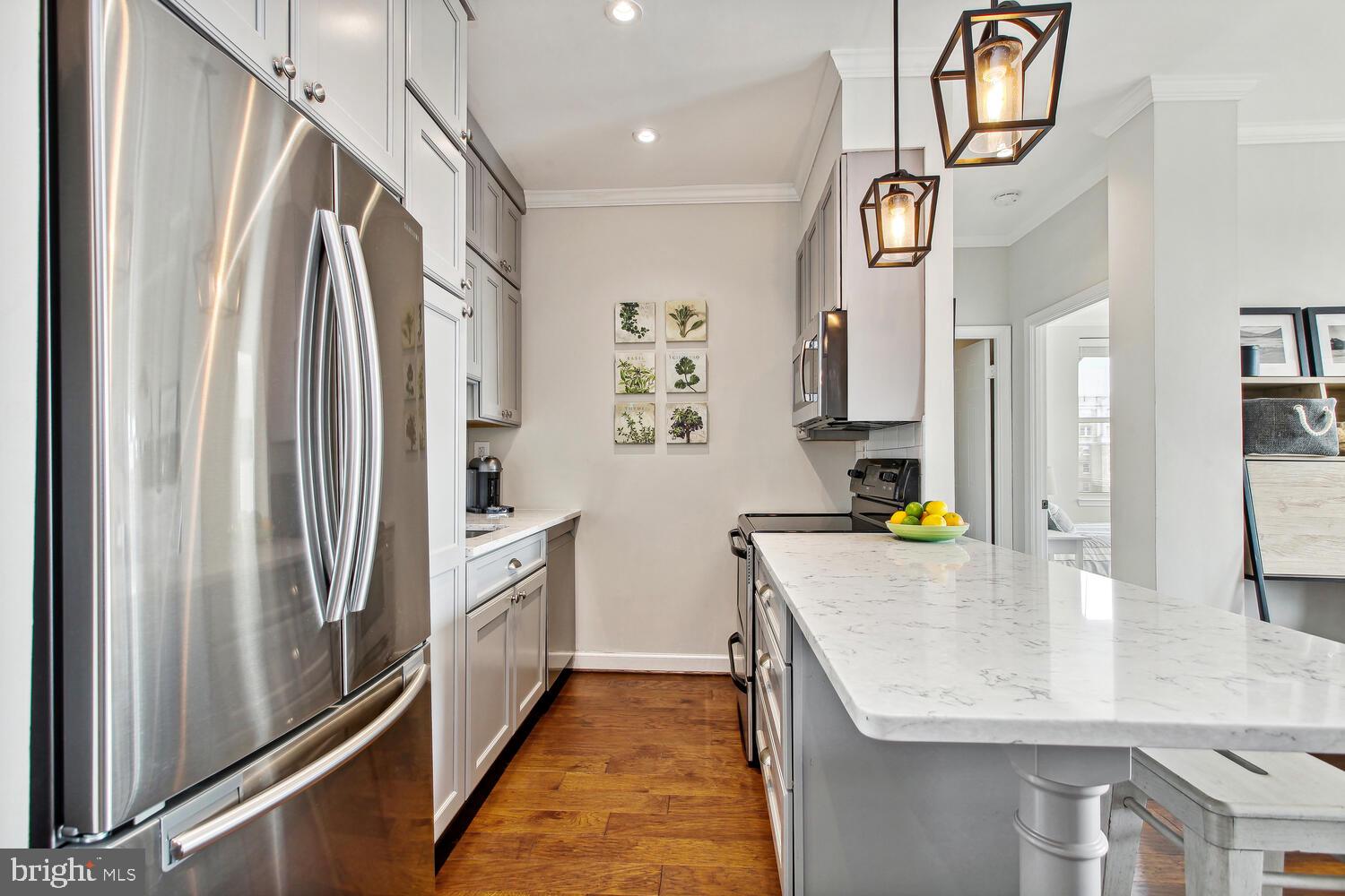 2000 16th Street Northwest, Unit 605 Washington, DC 20009 - Photo 10 of 16 a kitchen with stainless steel appliances granite countertop a refrigerator a oven and white cabinets with wooden floor