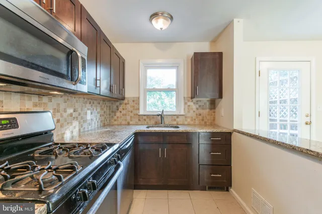 a kitchen with a stove a sink and a microwave
