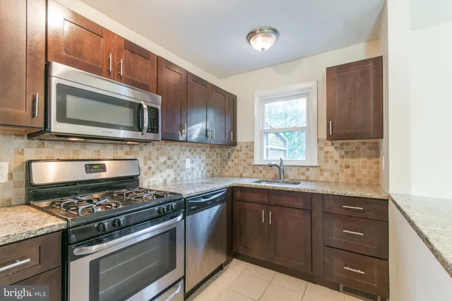 a kitchen with stainless steel appliances a sink stove and microwave