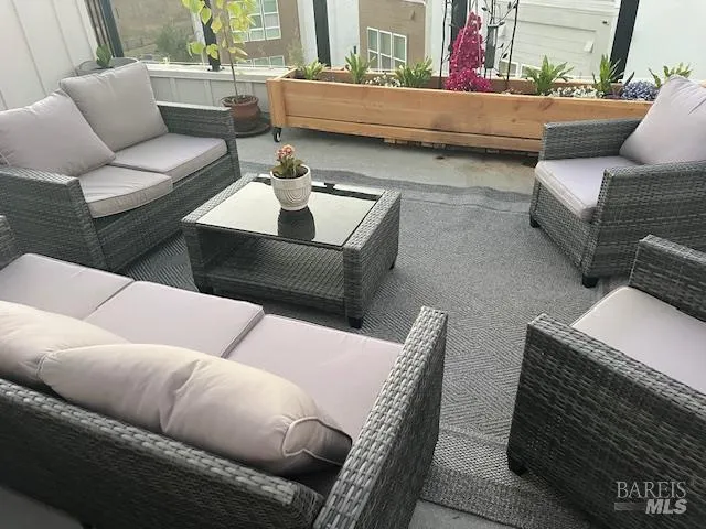 a outdoor living room with patio furniture and a potted plant