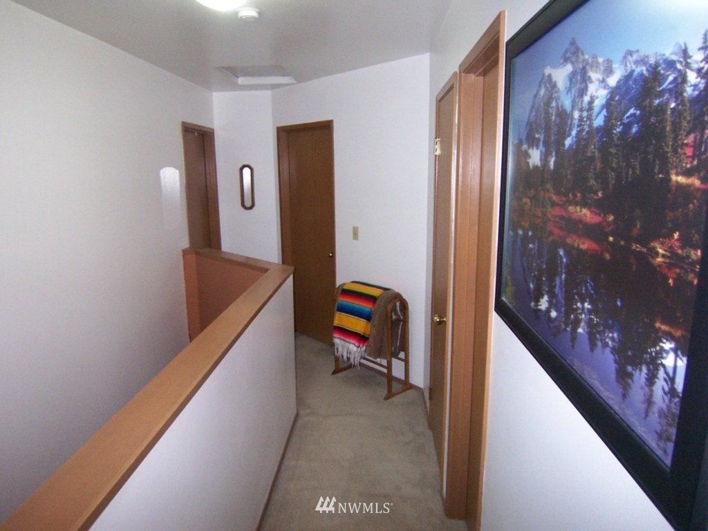 10624 Northeast 175th Street Bothell, WA 98011 - Photo 7 of 17 a hallway with painting on the wall and a large mirror