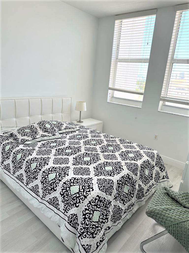 4100 Salzedo Street, Unit 702 Coral Gables, FL 33146 - Photo 6 of 15 a bed sitting in a bedroom next to a window