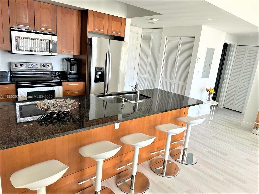 4100 Salzedo Street, Unit 702 Coral Gables, FL 33146 - Photo 9 of 15 a kitchen with stainless steel appliances granite countertop a sink and a refrigerator