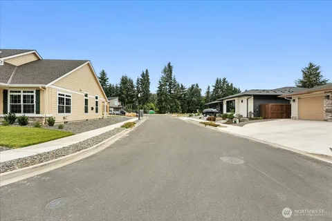 a house with a yard and a car park in front of it