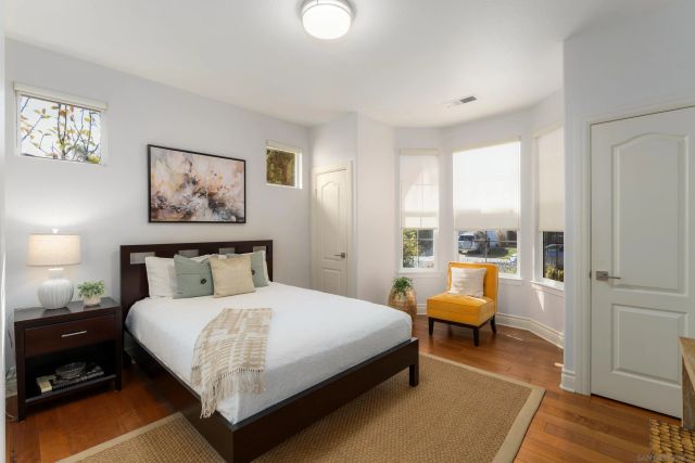 a large bedroom with a bed and wooden floor