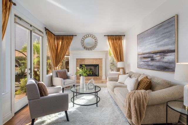 a living room with furniture fireplace and a large window