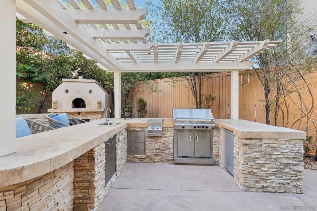 a view of a patio with a table and chairs under an umbrella with a large tree