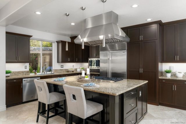 a kitchen with granite countertop a sink cabinets and stainless steel appliances