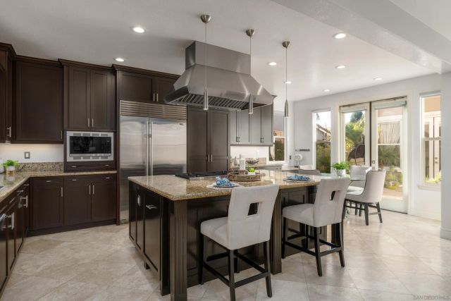 a kitchen with granite countertop a sink stove and refrigerator