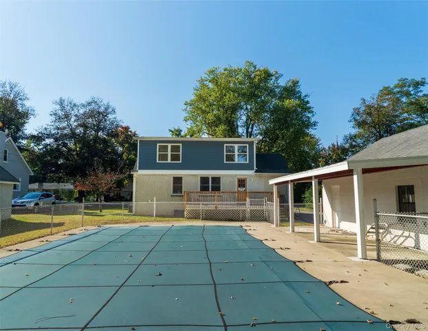 a view of a house with pool and sitting area