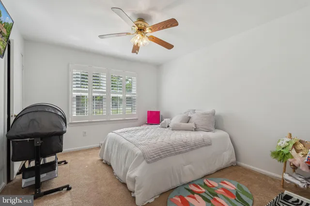 a bedroom with a bed a dresser and a chandelier