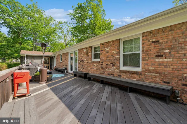 a view of a patio with table and chairs with wooden floor and fence
