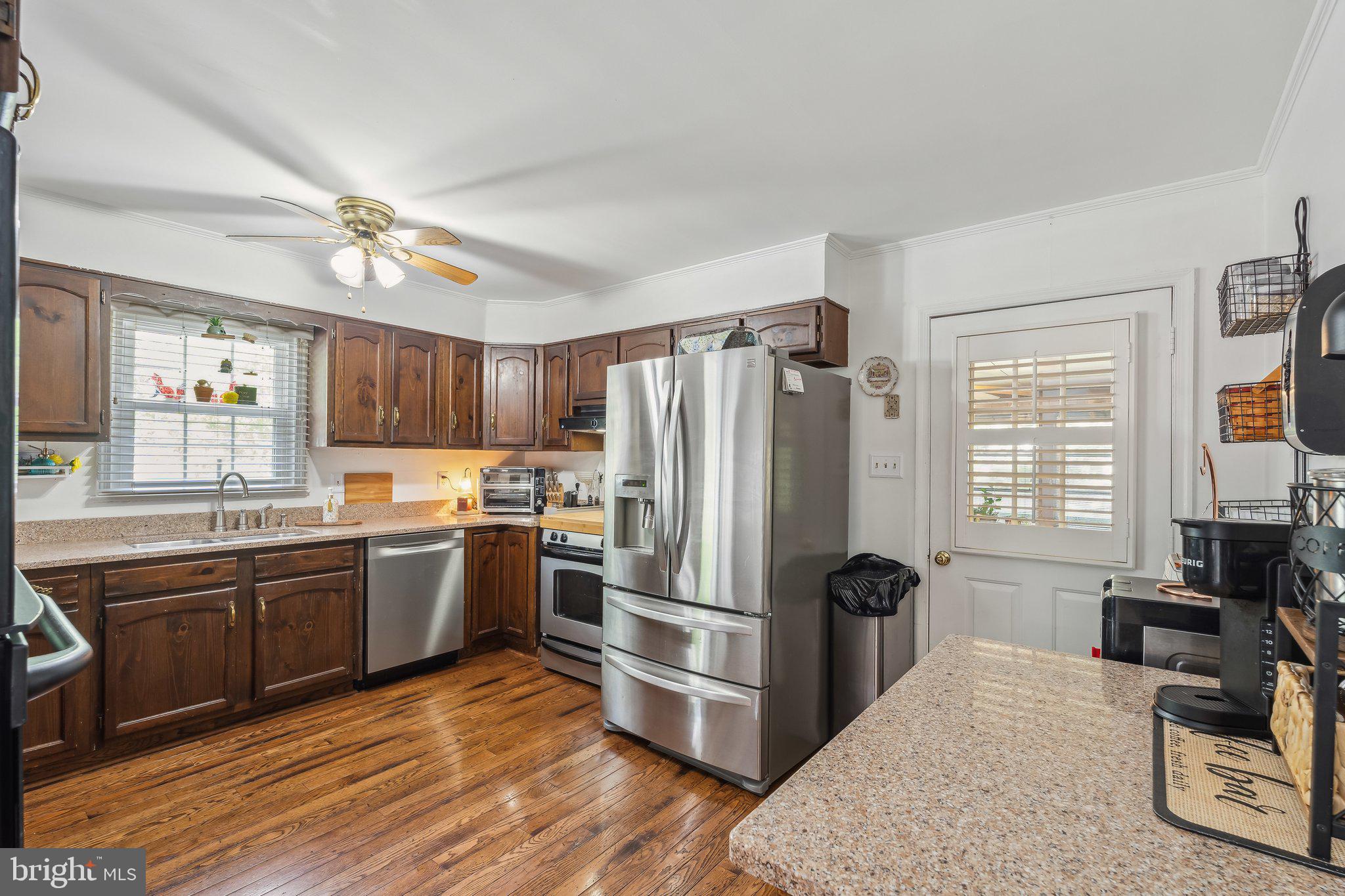 5232 Sumerduck Road Sumerduck, VA 22742 - Photo 8 of 40 a kitchen with stainless steel appliances granite countertop a refrigerator a sink dishwasher a stove and white countertops with wooden floor