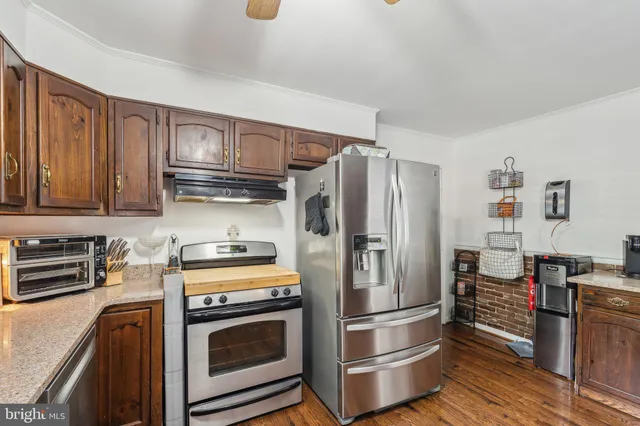 a kitchen with stainless steel appliances granite countertop a refrigerator stove and sink