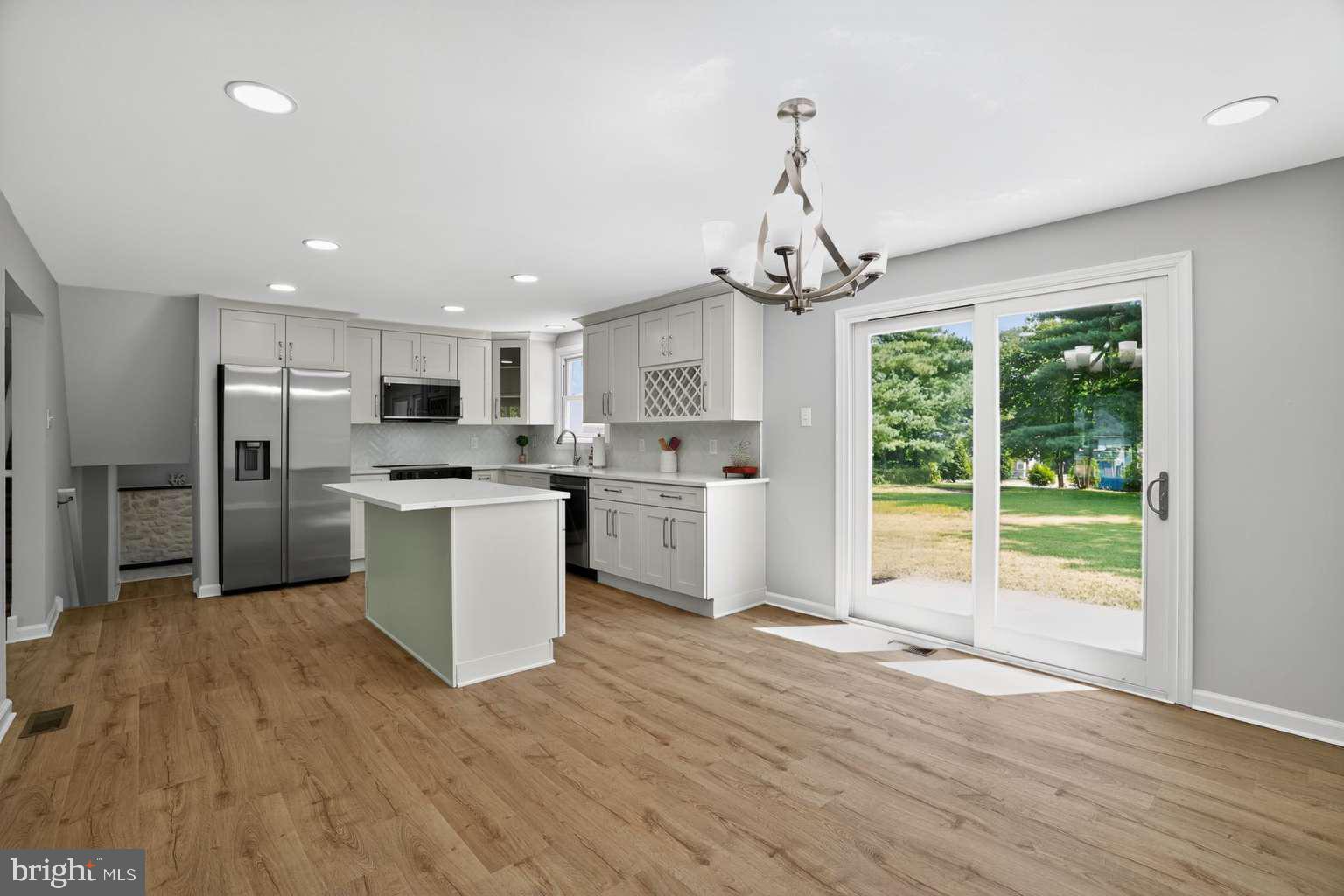 1841 Buck Road Feasterville-Trevose, PA 19053 - Photo 4 of 37 a kitchen with stainless steel appliances granite countertop a refrigerator a stove top oven a large window with wooden floor
