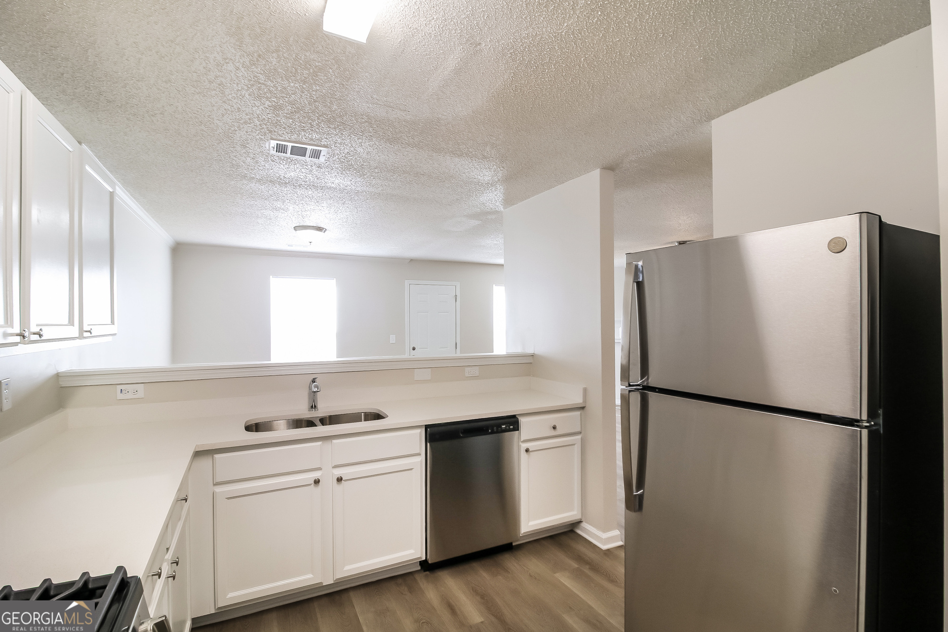 165 Colser Drive Covington, GA 30016 - Photo 6 of 17 a kitchen with a refrigerator sink and cabinets