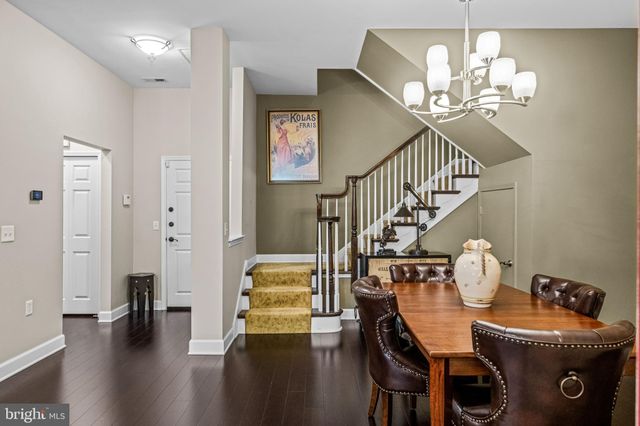a dining room with wooden floor chandelier and entryway